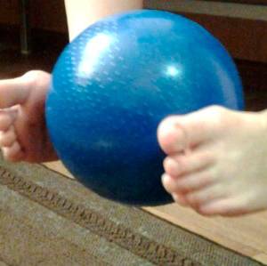 Поднимание мячика ногами